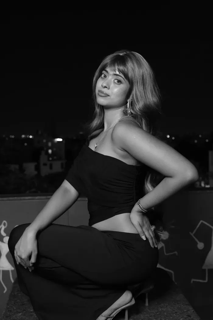 Black-and-white portrait of Sandipta posing with one hand on her hip
